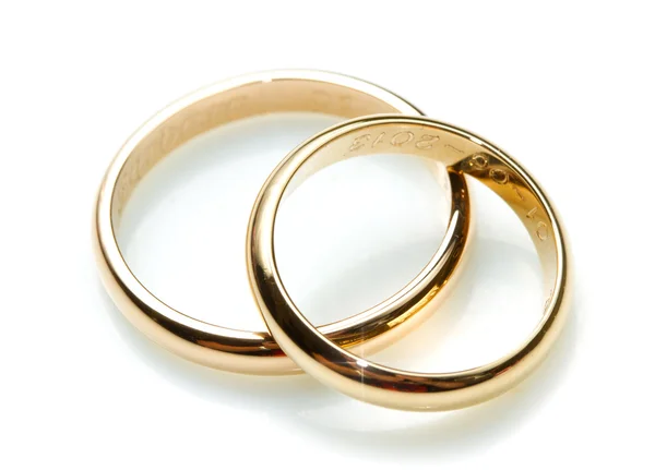 Pár zlatých snubních prstenů na bílém pozadí — Stock fotografie