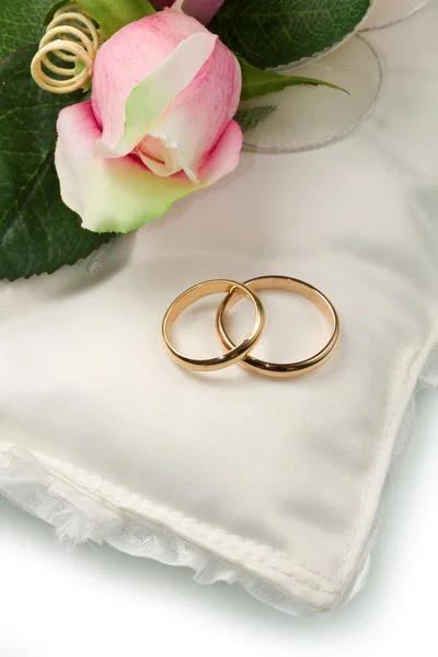 Wedding rings and pink roses on white pillow — Stock Photo, Image