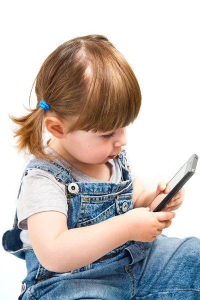 Klein meisje spelen met mobiele telefoon — Stockfoto