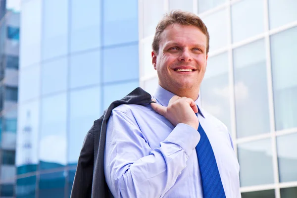 Smiling businessman standing outside a building — Stock Photo, Image