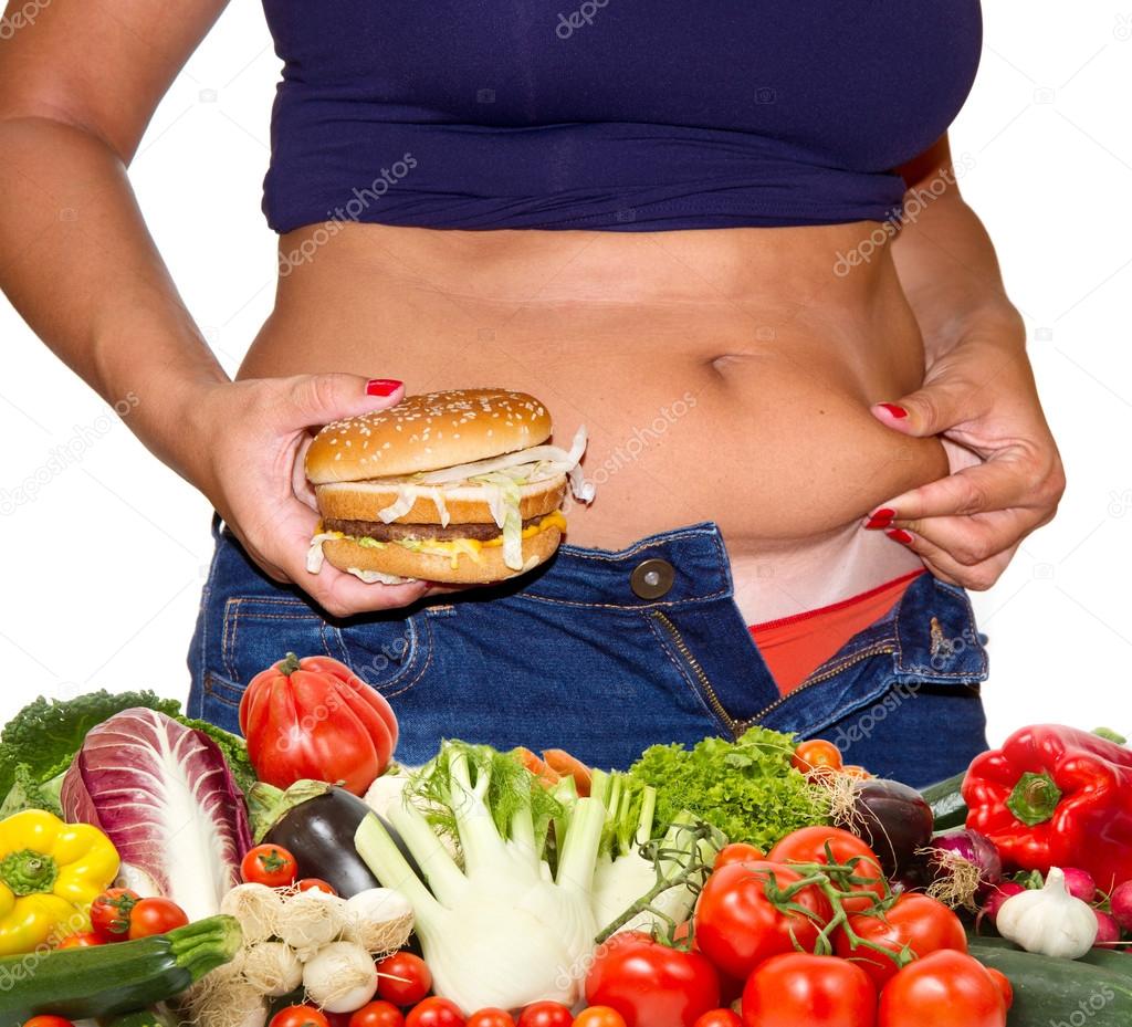 Fat woman with hamburger and vegetables