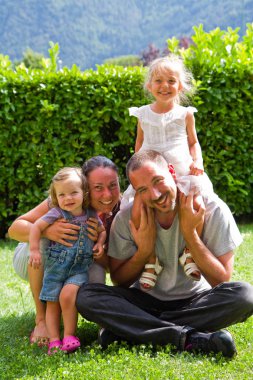 Yeşil çimenlerin üzerinde mutlu bir aile portresi