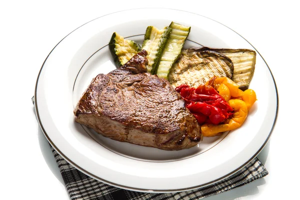 Delicious beef steaks on white dish with grilled vegetables — Stock Photo, Image