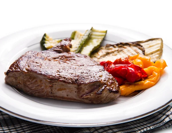 Bifes deliciosos de carne no prato branco com legumes grelhados — Fotografia de Stock