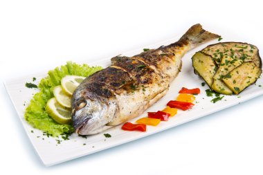 limon, salata ve ızgara plakası üzerinde yan kafa çipura ızgara