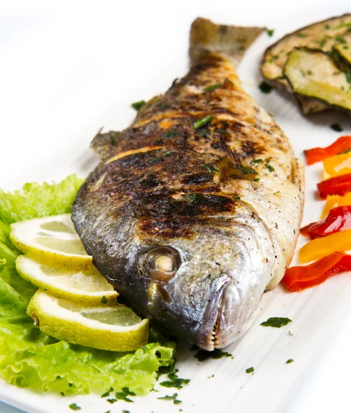 Grilled gilt head sea bream on plate with lemon ,salad and grill — Stock Photo, Image