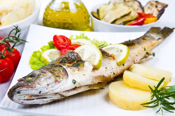 Fish, sea bass grilled with lemon ,salad and potatoes — Stock Photo, Image