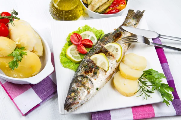 Pesce, spigola alla griglia con limone, insalata e patate — Foto Stock