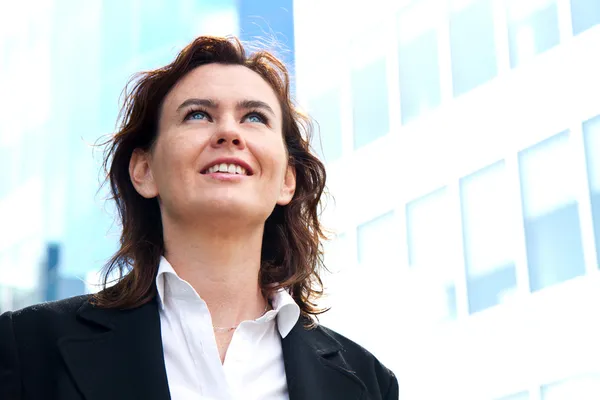 Tankeväckande affärskvinna tittar upp och ler — Stockfoto