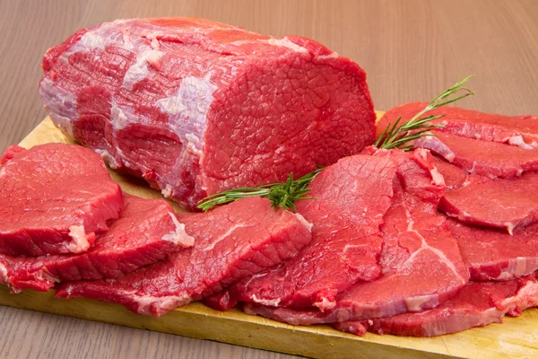 Το κομμάτι τεράστια κόκκινο κρέας και μπριζόλα στο ξύλινο τραπέζι — Φωτογραφία Αρχείου