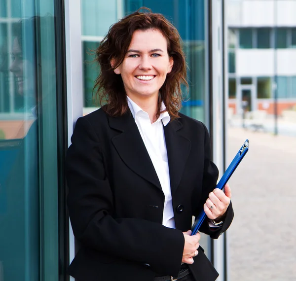 Young confident businesswoman with folder near the office build — Stock Photo, Image