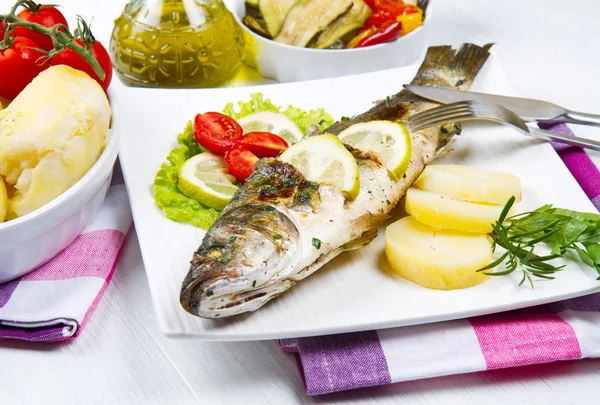 Fish, sea bass grilled with lemon ,salad and potatoes — Stock Photo, Image