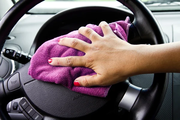 Χέρι της γυναίκας με πανί μικροϊνών στίλβωση τιμόνι ενός αυτοκινήτου — Φωτογραφία Αρχείου