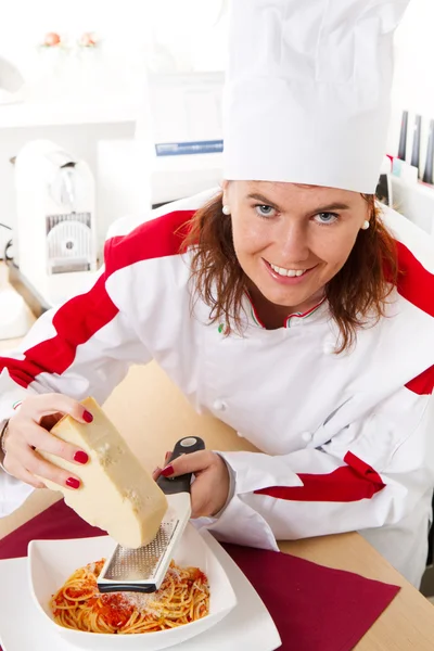 Smiling chef garnish an Italian pasta dish — Stock Photo, Image