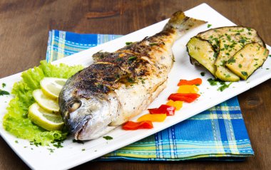 limon, salata ve ızgara plakası üzerinde yan kafa çipura ızgara