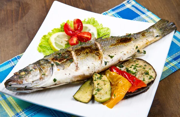 Fish, sea bass grilled with lemon and grilled vegetables — Stock Photo, Image