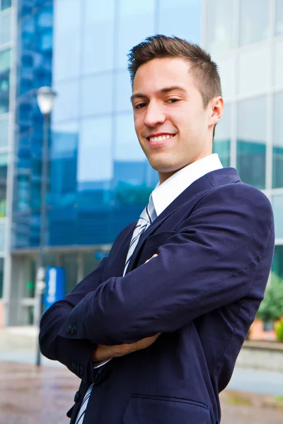 Uśmiechający się młody biznesmen, stojący na zewnątrz budynku — Zdjęcie stockowe