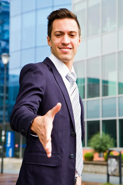 Jovem empresário sorridente do lado de fora de um edifício — Fotografia de Stock