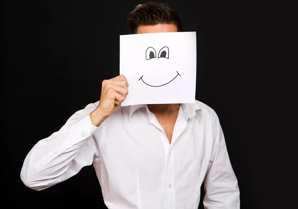 Jovem empresário segurando cartão branco com um rosto feliz — Fotografia de Stock