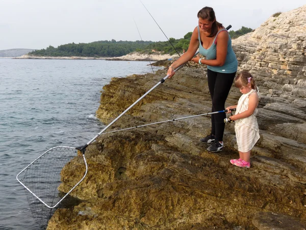 Mãe e filha de pesca no mar — Fotografia de Stock