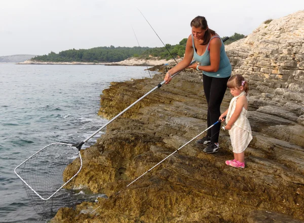 Mãe e filha de pesca no mar — Fotografia de Stock