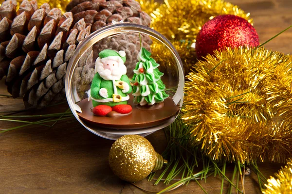 Christmas decoration and santa claus chocolate on wooden table — Stock Photo, Image