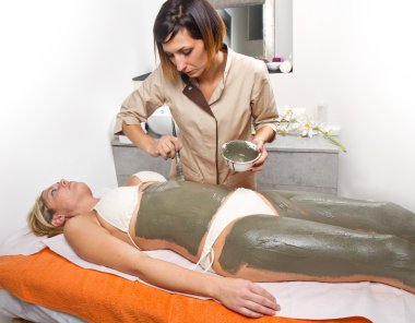 rahatlatıcı kadın çamur treatmen alan bir masaj masanın üzerinde yatan