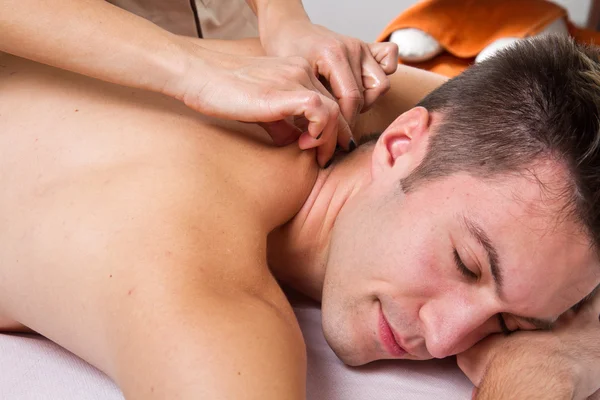Homem atraente ter uma massagem nas costas em um centro de beleza — Fotografia de Stock