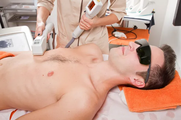 Young man receiving laser epilation on beauty center — Stock Photo, Image