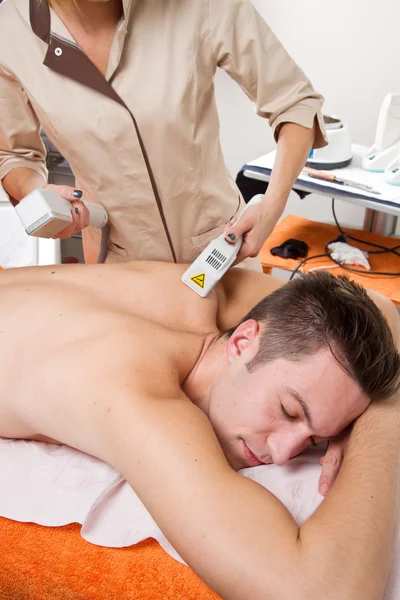 Junger Mann erhält Laser-Epilation auf Schönheitszentrum — Stockfoto