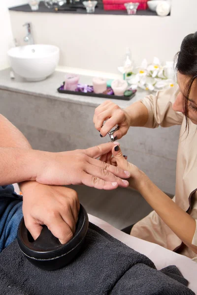 El cuidado de las uñas del hombre y la manicura en el centro de belleza — Foto de Stock