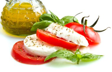 domates ve mozzarella ile fesleğen yaprakları üzerine beyaz