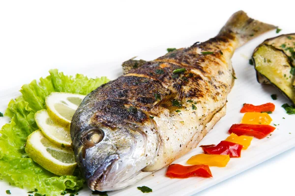 limon, salata ve ızgara plakası üzerinde yan kafa çipura ızgara