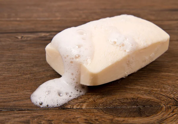 Bolha de sabão branco de isolamento em um fundo de madeira — Fotografia de Stock