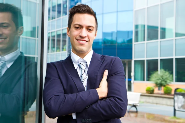 Leende ung affärsman står utanför en byggnad — Stockfoto