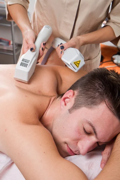 Junger Mann erhält Laser-Epilation auf Schönheitszentrum — Stockfoto