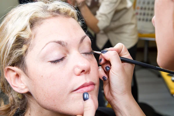 Maquillaje artista aplicando maquillaje de cejas — Foto de Stock