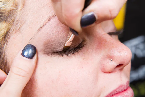 Maquillaje artista aplicando maquillaje de cejas — Foto de Stock