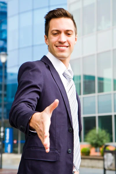 Jovem empresário sorridente do lado de fora de um edifício — Fotografia de Stock