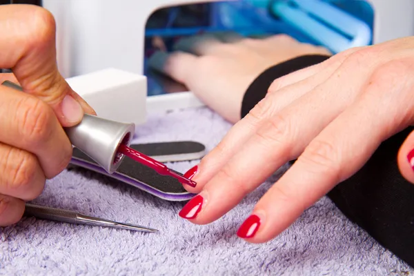Manicure en handen met UV-lamp voor nagels — Stockfoto