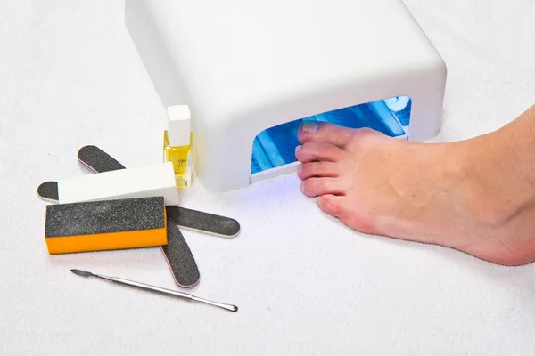 Feet with uv lamp for nails — Stock Photo, Image