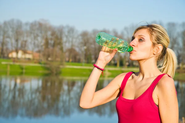Woman drinking water from bottle after fitness sport exercise — Stock Photo, Image