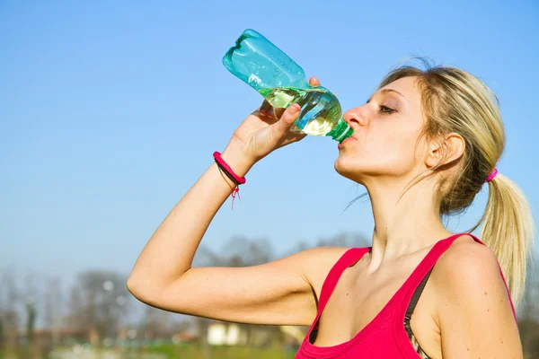 Woman drinking water from bottle after fitness sport exercise — Stock Photo, Image