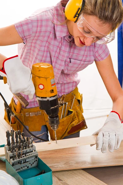 Vrouwelijke timmerman aan het werk met behulp van handboormachine — Stockfoto