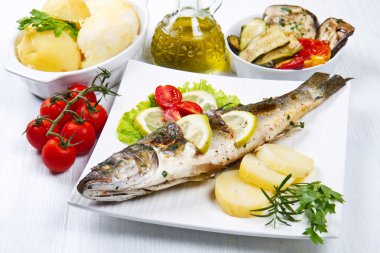 Balık, limon, salata ve patates ile ızgara levrek