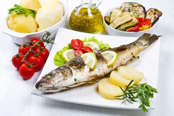 Pesce, spigola alla griglia con limone, insalata e patate — Foto Stock