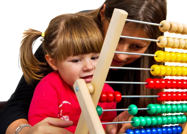 Mother and her little daughter learning math with abacus — Stock Photo, Image