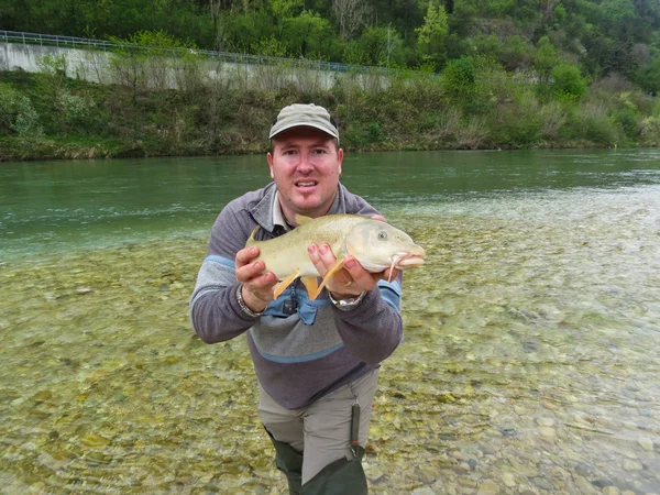 Pêcheur tenant un poisson frais pêché — Photo