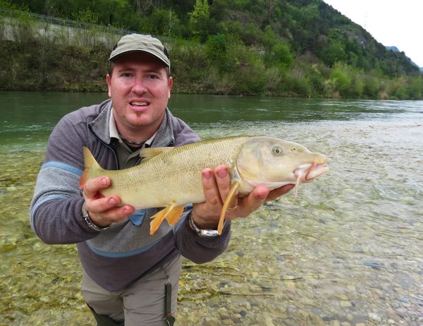 Pêcheur tenant un poisson frais pêché — Photo