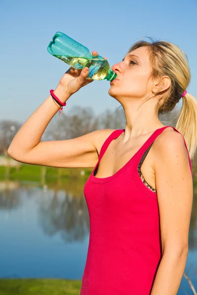 Woman drinking water from bottle after fitness sport exercise — Stock Photo, Image